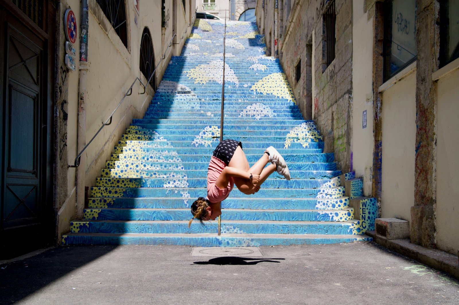 a person doing a handstand on a stair case