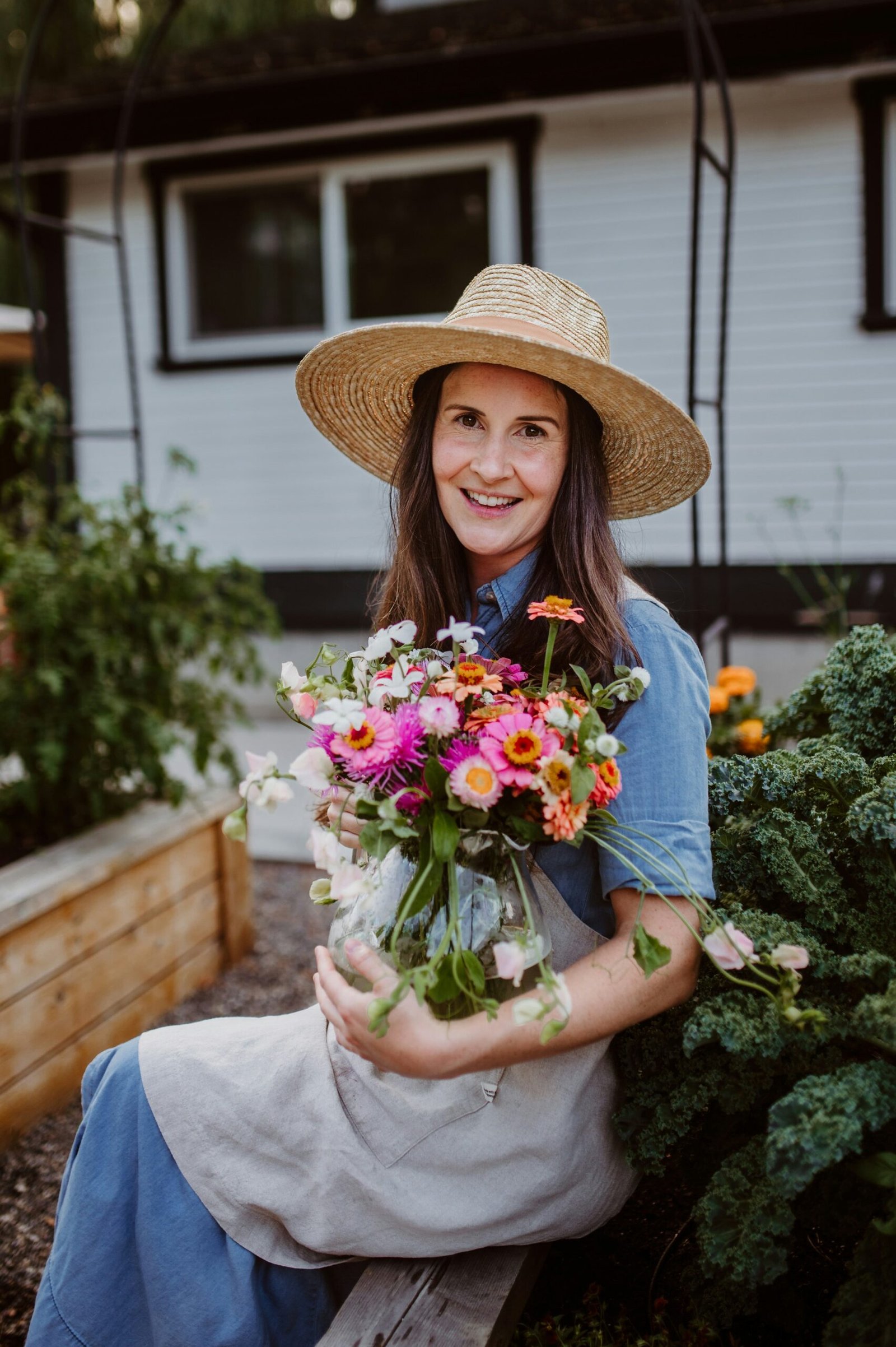 A woman sitting on a bench holding a bouquet of flowers